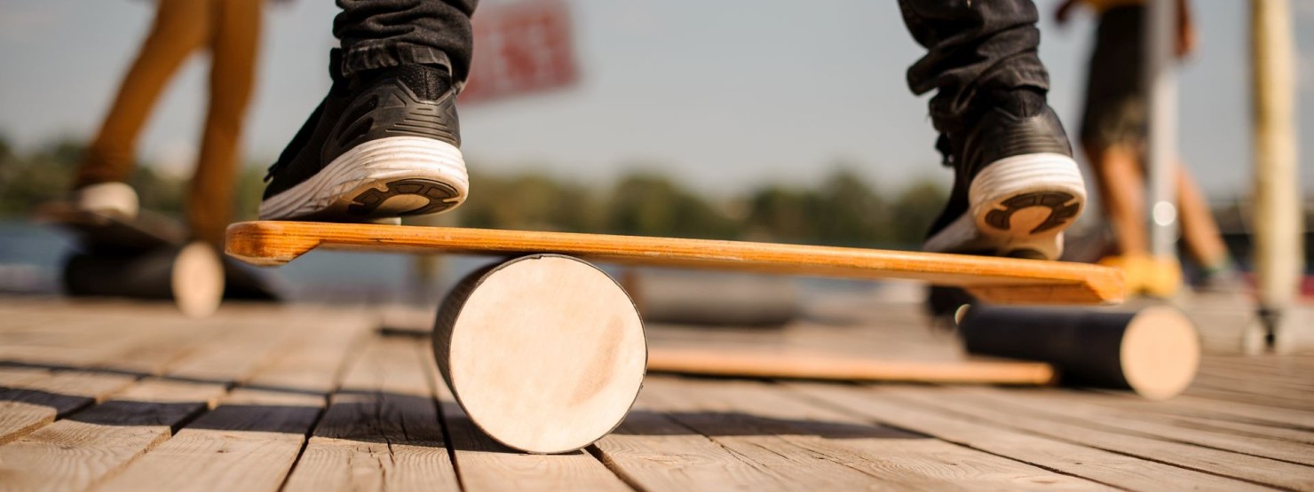 Junge Frau steht auf Balance Board