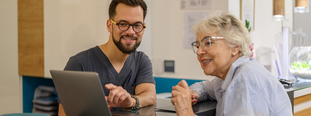 Eine Patientin lässt sich ihre Untersuchungsergebnisse von einen Optiker erklären