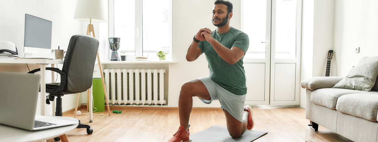 Junge Frau macht Homeworkout im Wohnzimmer