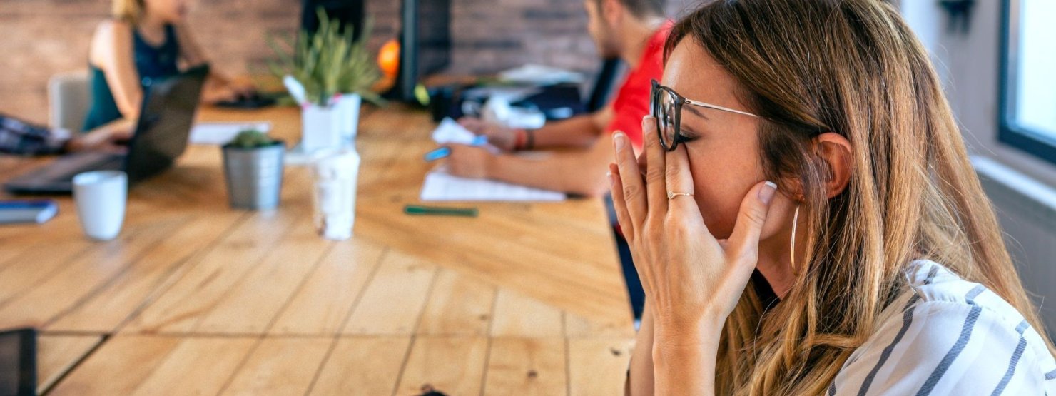 Junge Frau Anfang 20 schiebt die Brille hoch und reibt sich die Augen