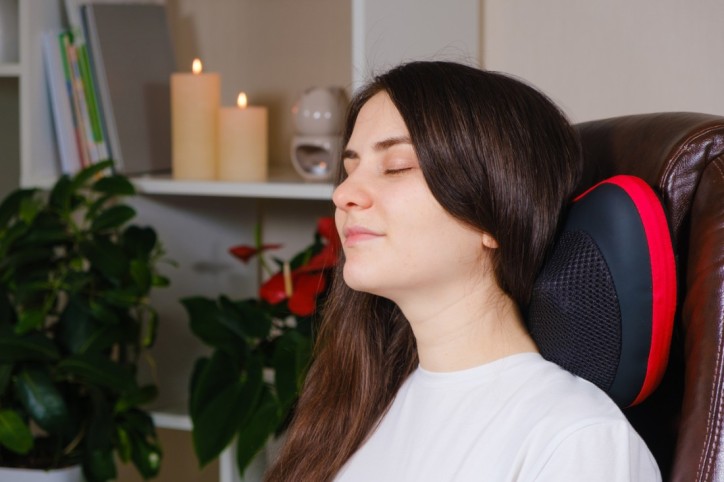 Eine junge Frau nutzt ein Massagekissen 