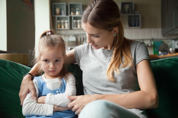 Eine Mutter tröstet ihre trotzende Tochter