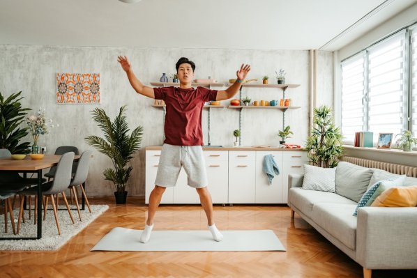 jUNGER MANN MACHT HAMPELMÄNNER IN SEINEM WOHNZIMMER
