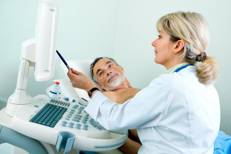 Eine Ärztin untersucht per Ultraschall einen Patienten auf Aneurymen an der Bauchaorta.