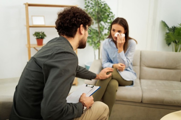 Eine Frau weint aufgrund eines Traumatas vor ihem Psychotherapeuten