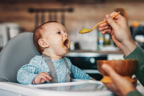 Baby macht freudig Mund weit auf für leckeren Babybrei. - AOK Sachsen-Anhalt begleitet mit exklusiven Leistungen für Eltern mit Babys.