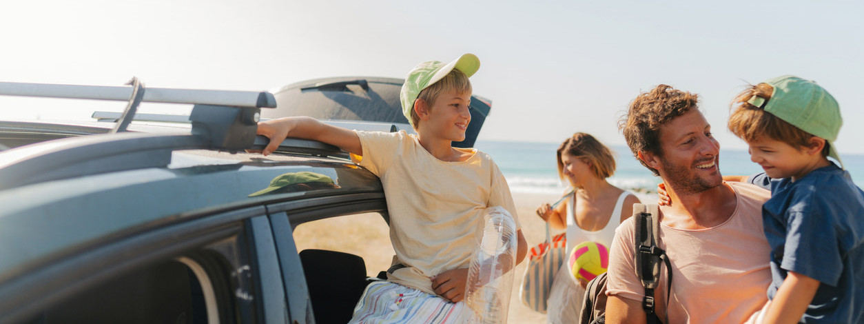 Junge Familie am Strand im Urlaub genießt den Schutz der AOK Sachsen-Anhalt.