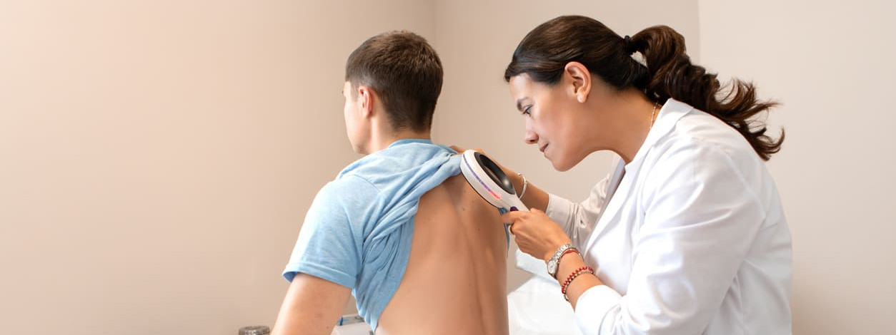 Dermatologin untersucht jungen Patienten