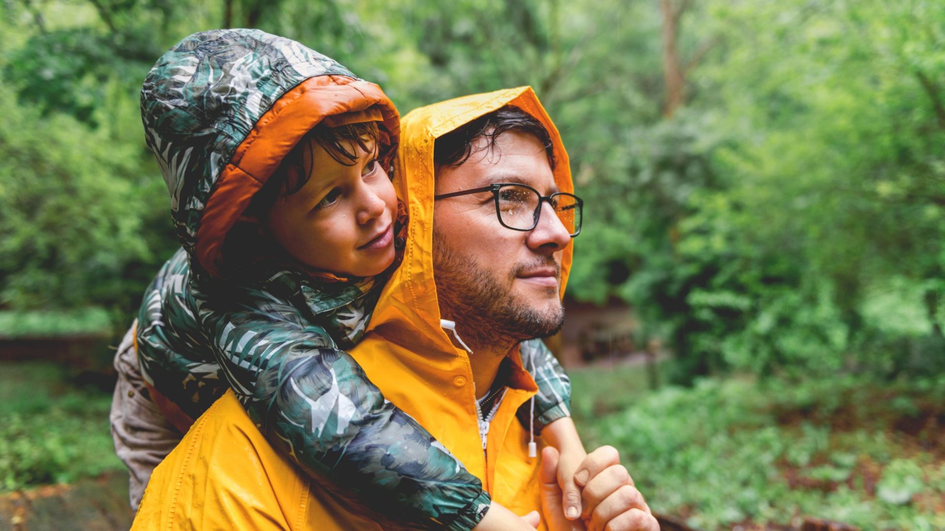 Vater und Sohn haben Spaß an regnerischen Tagen.