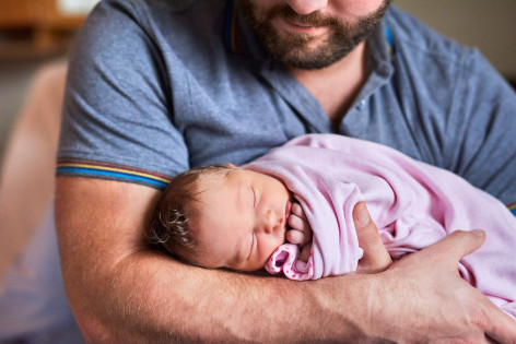Vater hält ein Baby im Arm