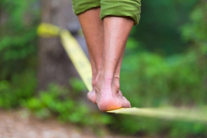 Zwei Füße auf einer Slackline.