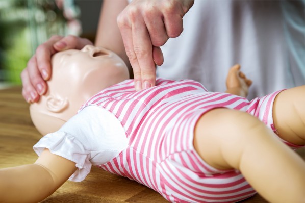 An einer Kinderpuppe wird Erste-Hilfe gezeigt.