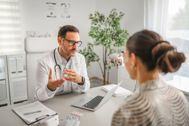 Ein Arzt berät eine Patientin zu einer Biopsie