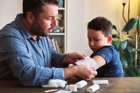 Ein Vater wendet Erste-Hilfe-Maßnahme bei seinem Sohn an