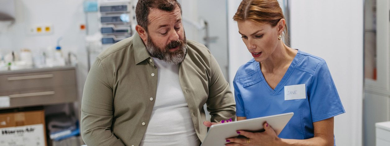 Eine Ärztin erläutert einem Patienten seine Blutfettwerte