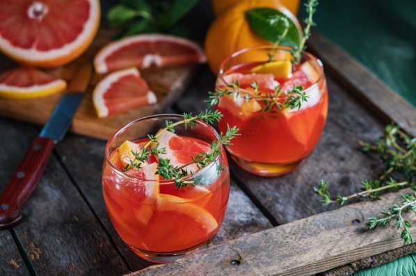 Grapefruit and thyme cocktail. Refreshing drink on rustic background.
