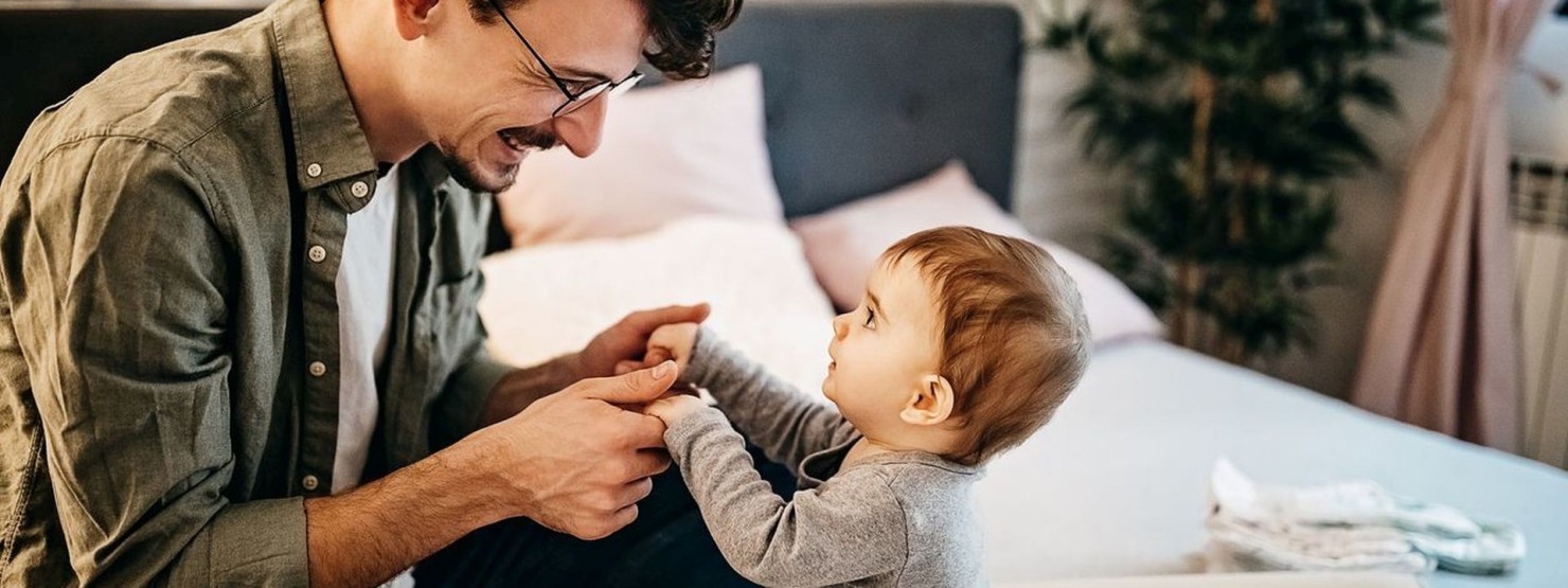 Ein Vater spielt mit seinem Baby mit KiSS-Syndrom.