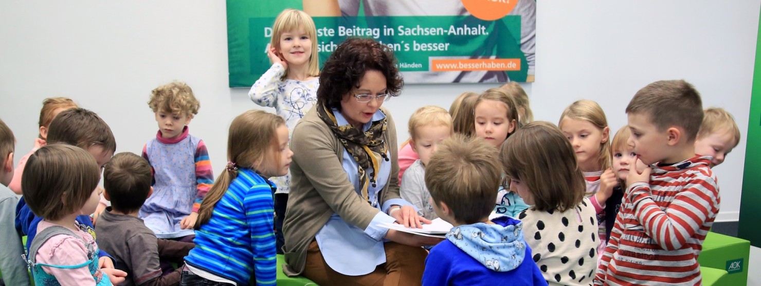 AOK-Mitarbeiterin liest Kindern etwas vor