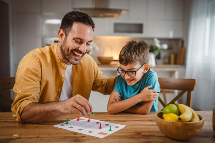 Ein Vater und sein Sohn erleben Glückshormone beim gemeinsamen Brettspiel