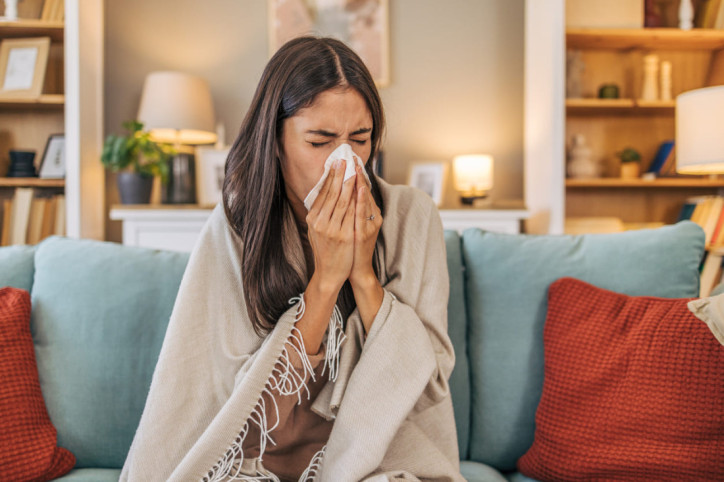 Eine Frau verspürt typische Symptome aufgrund von Period Flu