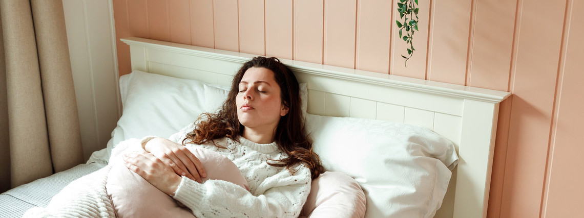 Eine Frau leidet unter Amenorrhoe und liegt im Bett