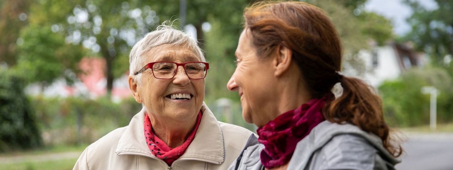 Glückliche ältere Frau und Pflegekraft.