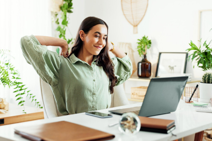 Eine junge Frau integriert Stretching in ihre Arbeitsalltag