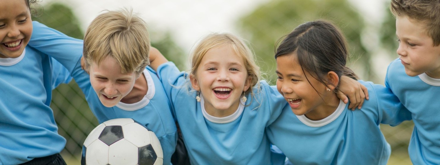 Eine Kinder-Fußballgruppe feiert ihren Sieg.