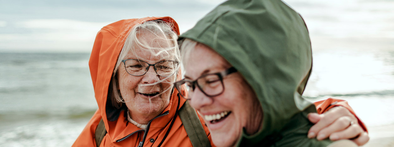 Zwei Seniorinnen stärken ihr Immunsystem bei einem Strandspaziergang