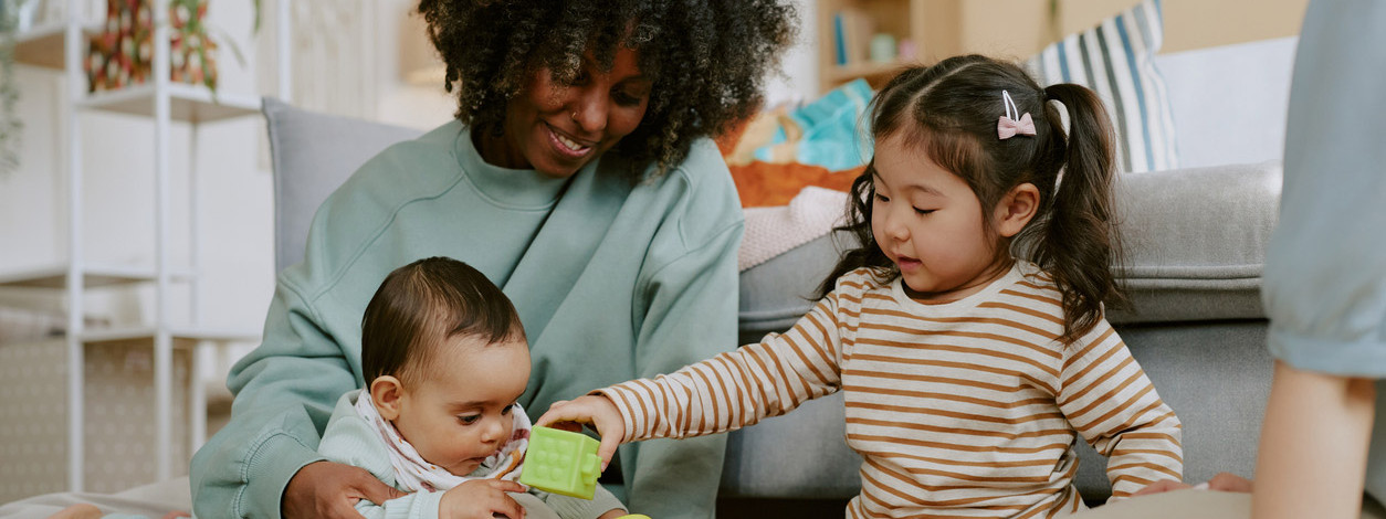 Eine Mutter fördert die Fingerfertigkeit ihrer Kinder mit Bausteinen
