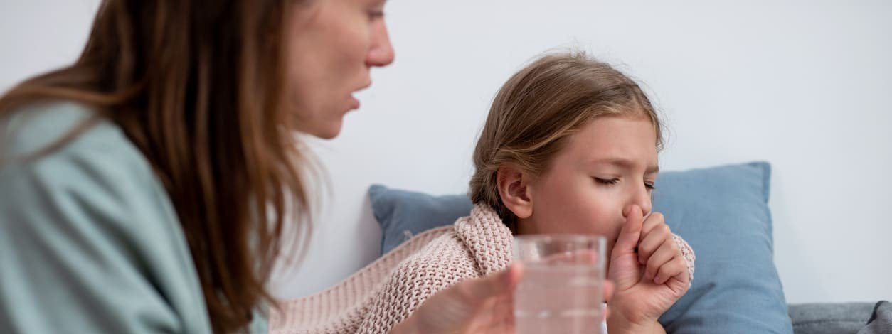 Eine Mutter pflegt ihre an Keuchhusten erkrankte Tochter
