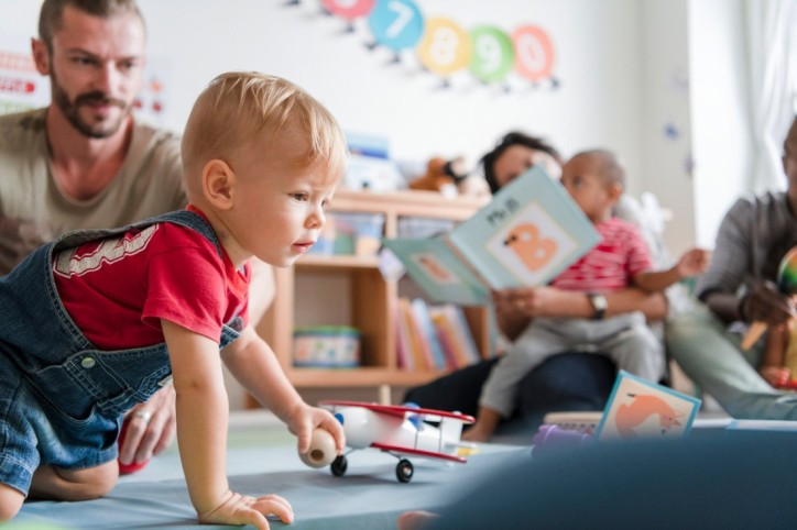 Ein Vater und sein Sohn spielen gemeinsam bei einem Babykurs
