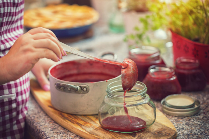 Frisch gekochte Marmelade wird in Einmachglas umgefüllt