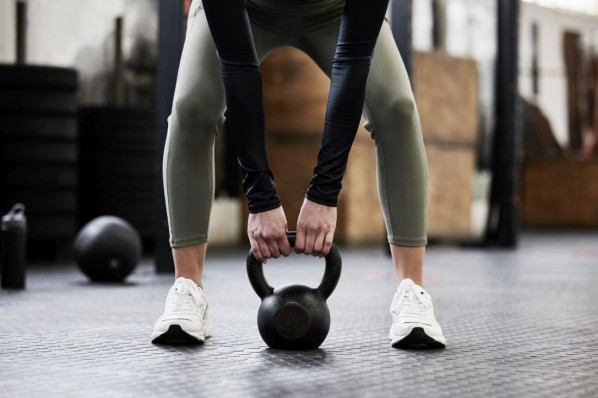 Junge Frau hält Kettlebell in der Hand.