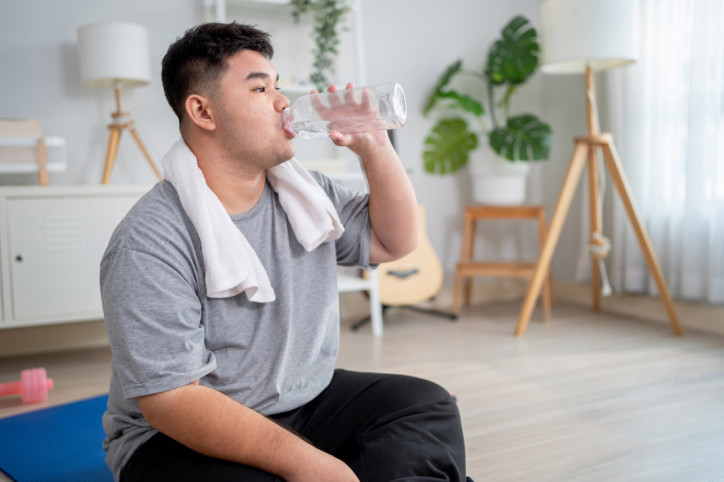 Ein junger Mann beugt eine Synkope mit ausreichender Flüssigkeitszufuhr vor