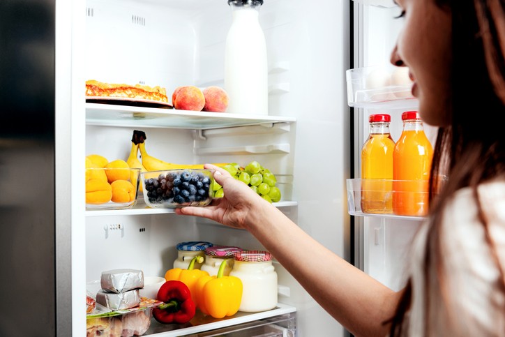 Eine Frau stellt Heidelbeeren in den Kühlschrank