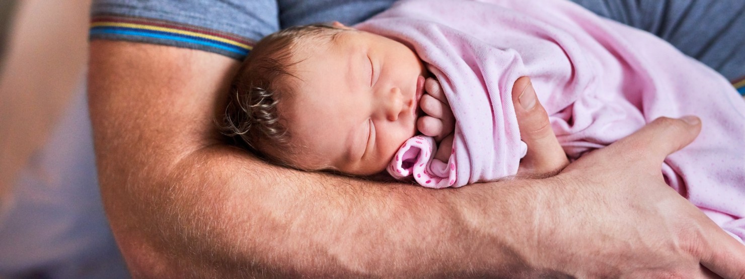 Vater hält Baby im Arm