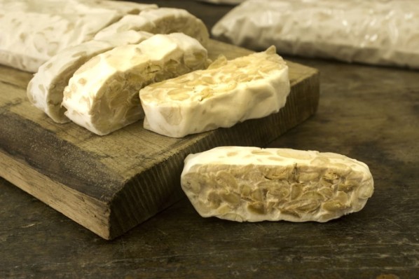 Tempeh liegt als Fleischersatz auf einem Brett