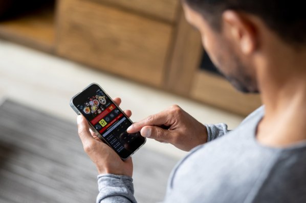 Mann spielt Glücksspiel am Smartphone