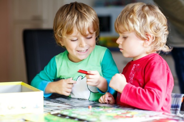 Zwei jungen blonden Kind zusammen spielen Brettspiel in der Kita