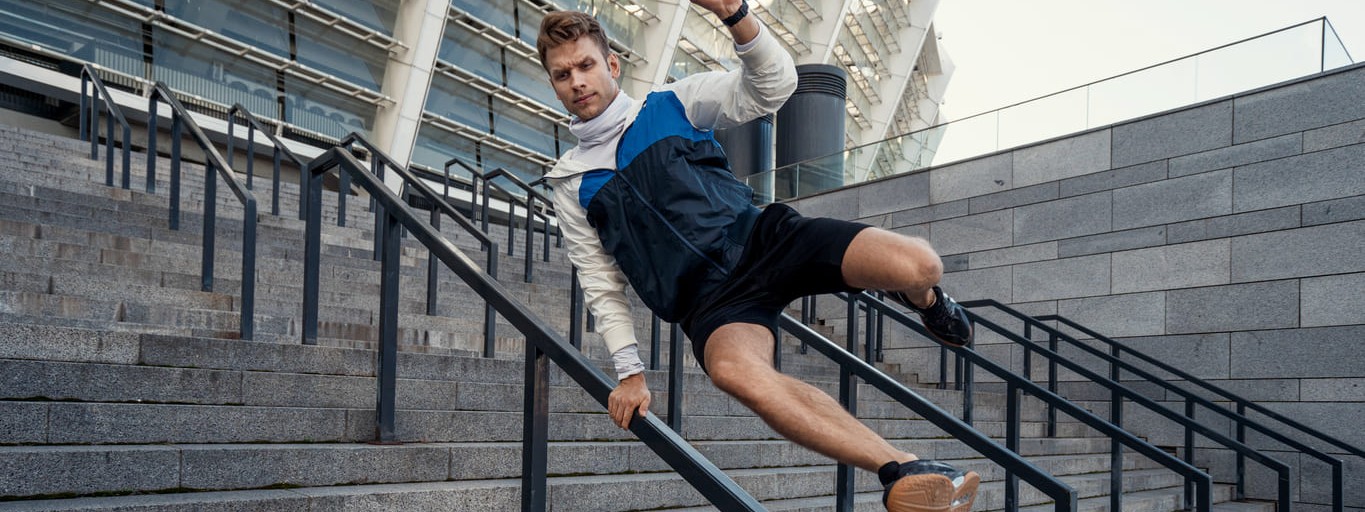 Ein Mann beim Parkour an einem Treppengeländer