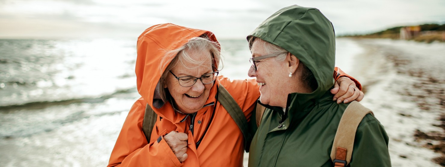 2 Frauen lachen beim Strandspaziergang