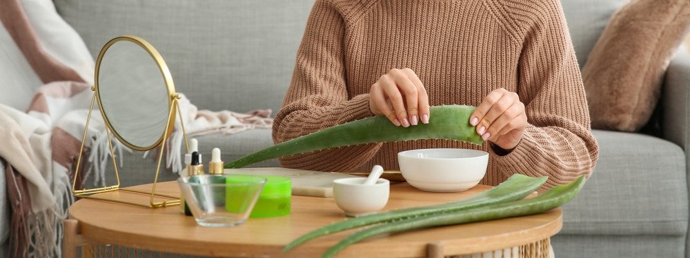 Eine junge Frau bereitet Aloe vera Blätter vor, um selbst Gel zuzubereiten.