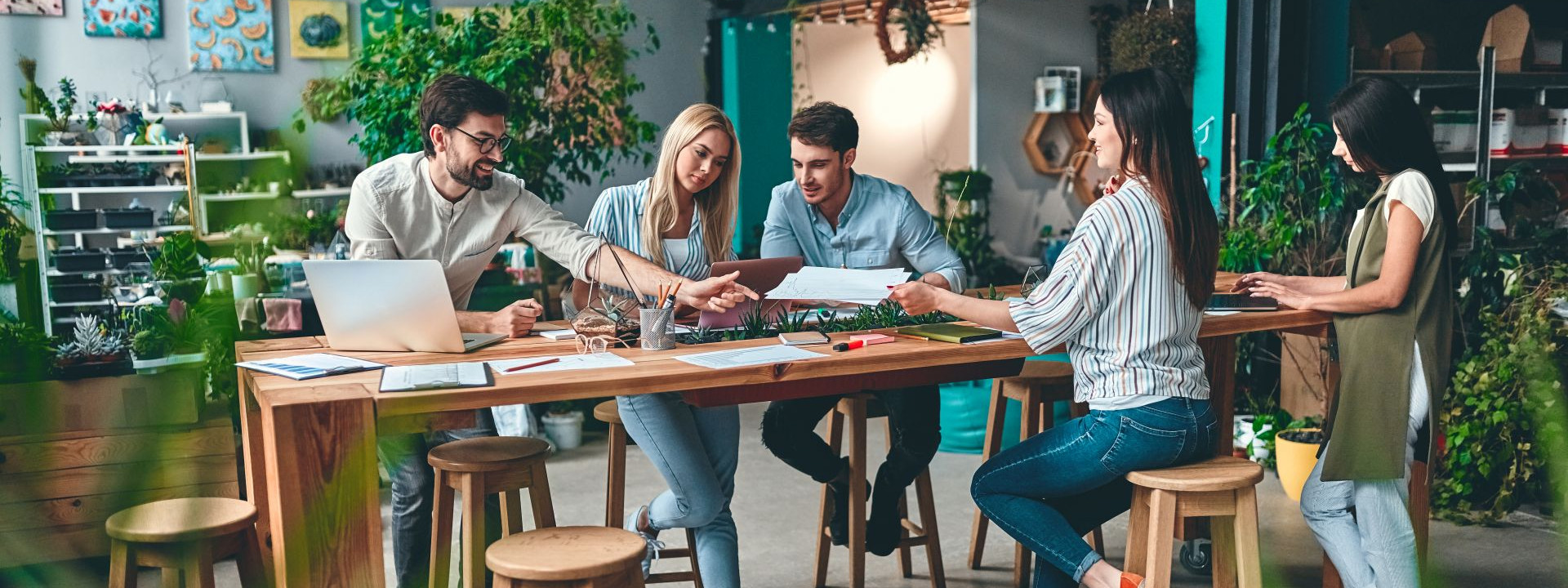 Gruppe von Menschen stehen am Tisch und machen einen workshop.