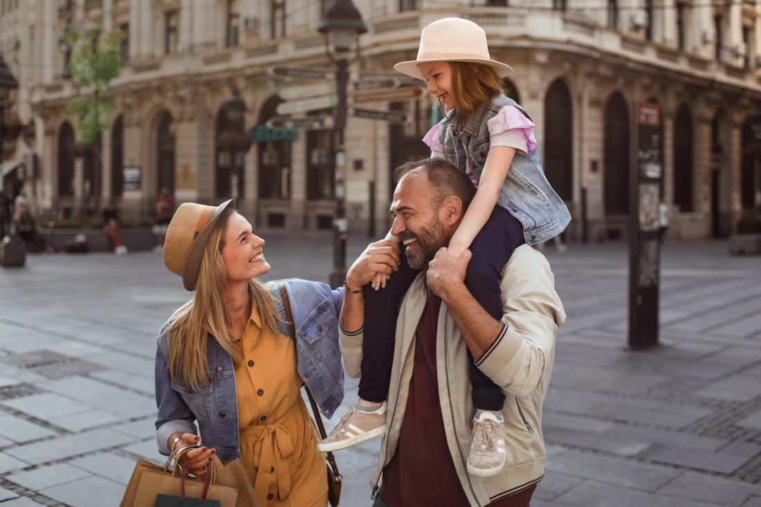 Glückliche Familie genießt Stadtbummel im Sonnenschein. - AOK Sachsen-Anhalt begleitet mit starken Leistungen.