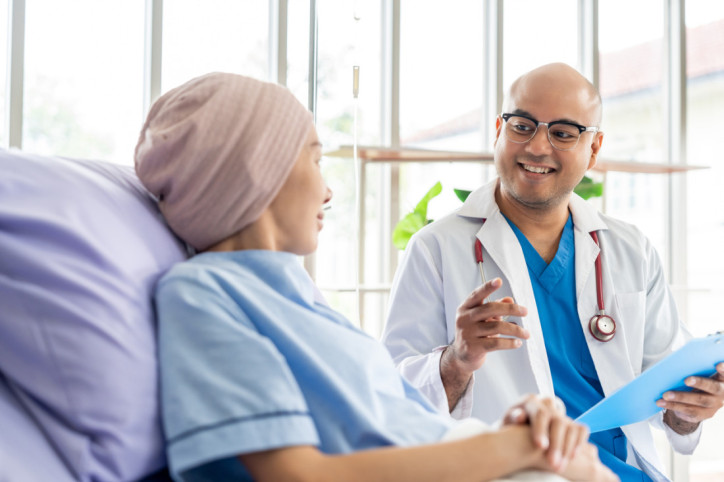 Ein freundlicher Onkologe besucht eine Krebspatientin am Krenkenbett
