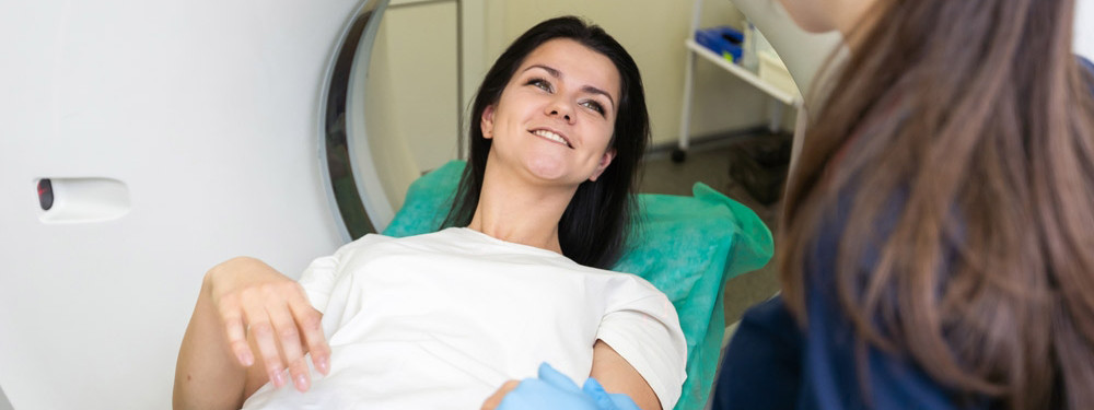 Eine Patientin wird mithilfe eines Computertomografen behandelt