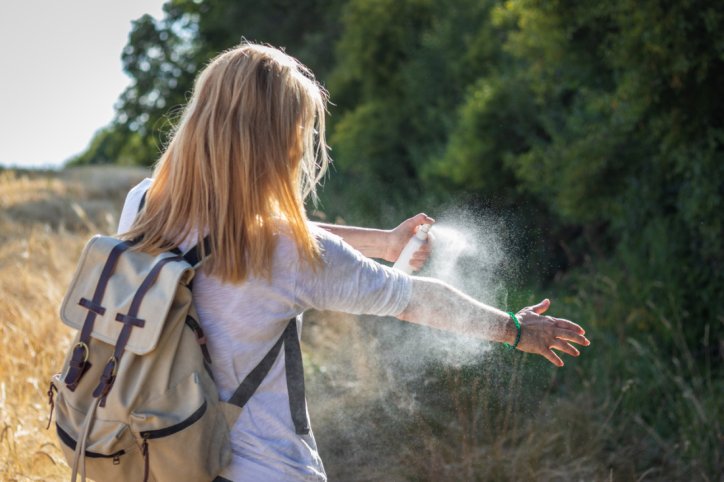 Frau nutzt Repellentien zum Mückenschutz.