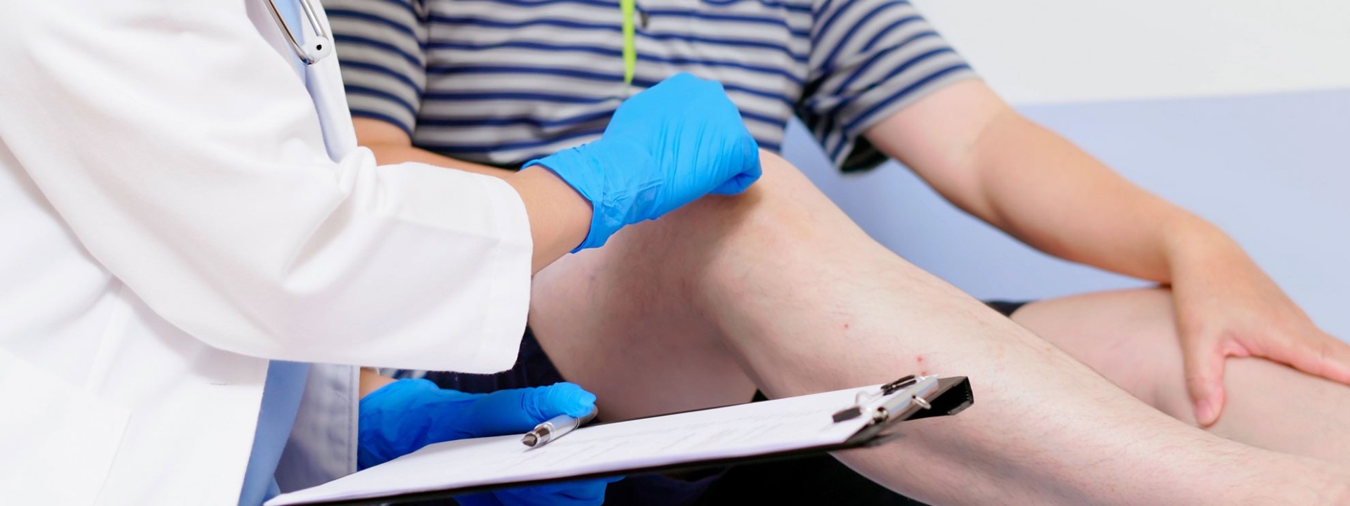 Ein Mediziner untersucht die Beine eines Patienten