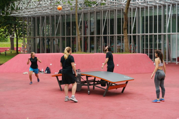 Eine Gruppe von vier Personen spielt gemeinsam Teqball auf einem Teqboard.